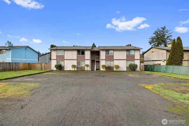 a view of a house with backyard and a tree