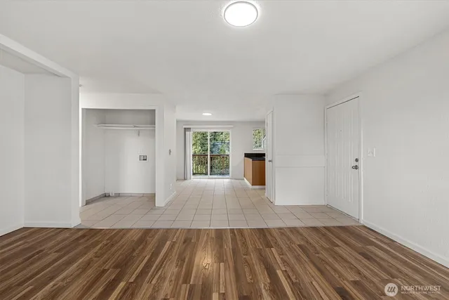 a view of empty room with wooden floor and entryway