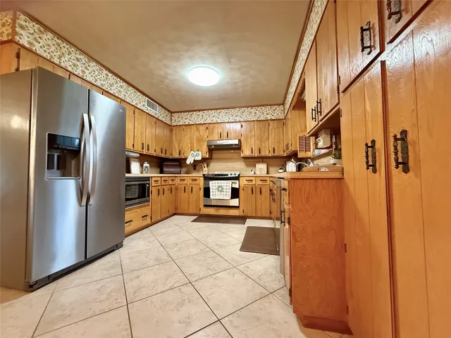 a kitchen with stainless steel appliances granite countertop a refrigerator and a sink