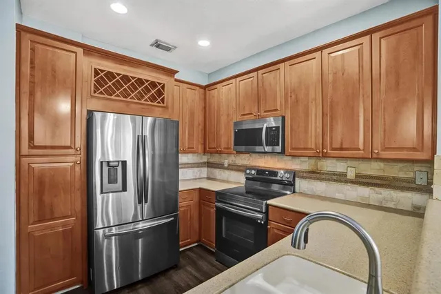 a kitchen with stainless steel appliances granite countertop a refrigerator and a stove top oven