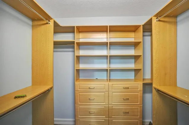 a view of walk in closet with empty racks