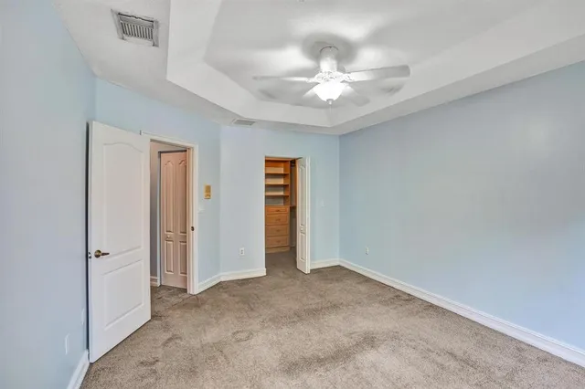 a view of an empty room with a chandelier fan