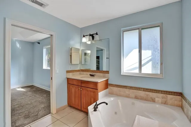 a bathroom with a tub sink and mirror