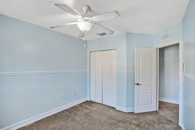 an empty room with a ceiling fan and a window