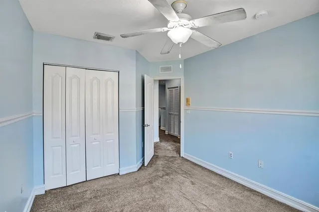 an empty room with a ceiling fan and a window