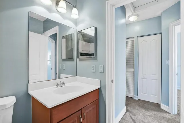 a bathroom with a sink a toilet and a mirror