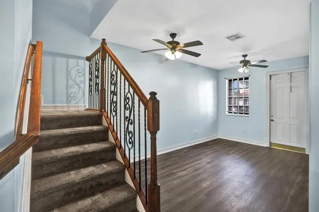 a view of a hallway with wooden floor and entryway