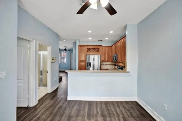 a living room with stainless steel appliances kitchen island hardwood floor and a view of kitchen