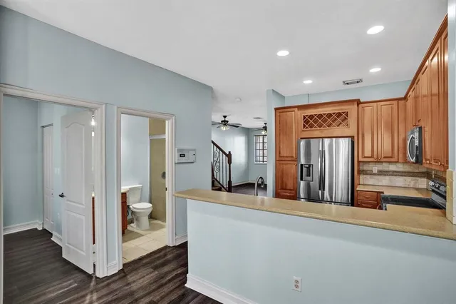 a view of a hallway with entryway and wooden floor