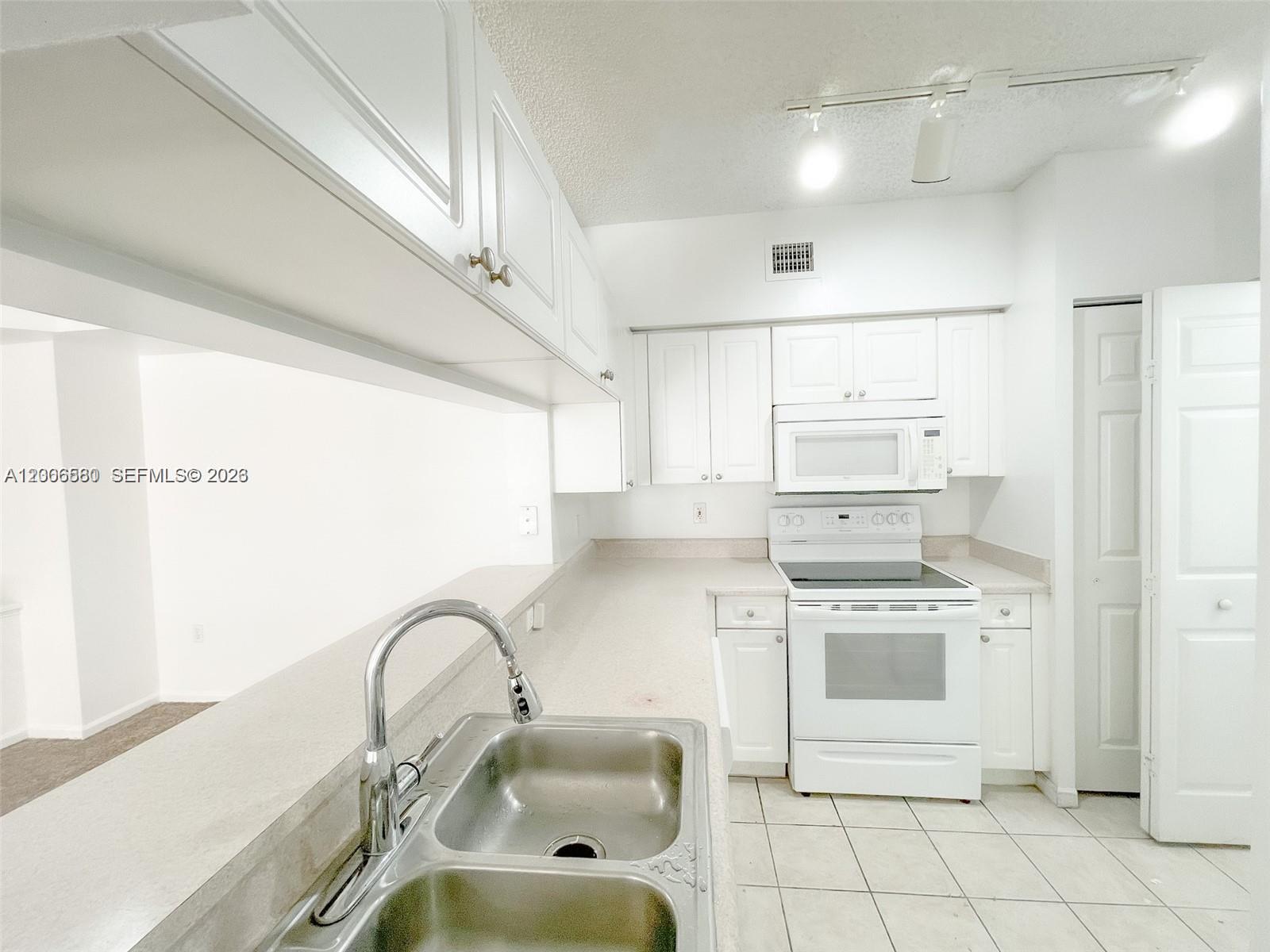 17150 North Bay Road, Unit 2602 Sunny Isles Beach, FL 33160 - Photo 11 of 27 a kitchen with a stove a sink and a refrigerator