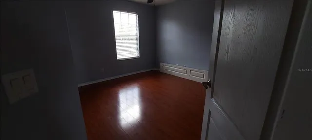 en empty room with windows and ceiling fan
