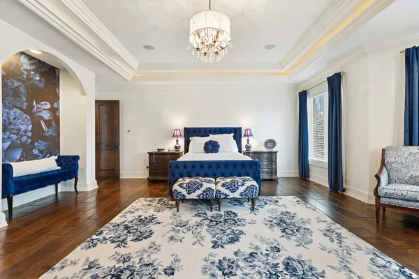 a spacious bedroom with a large bed and a chandelier