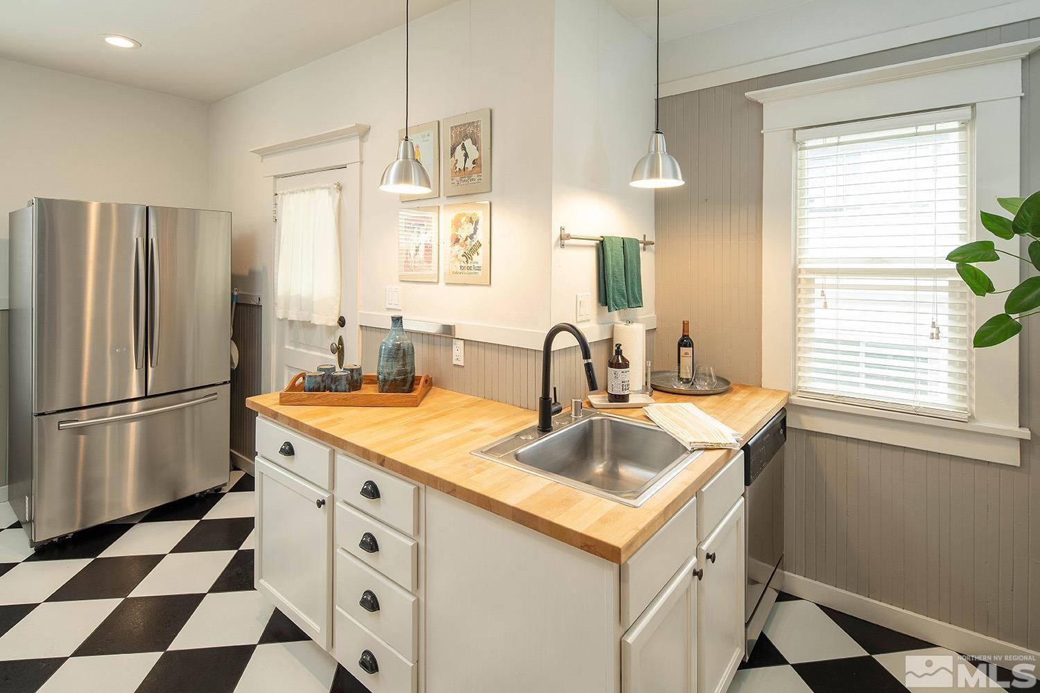 742 Plumas Street Reno, NV 89509 - Photo 21 of 40 a kitchen with a sink a refrigerator a window and a kitchen island