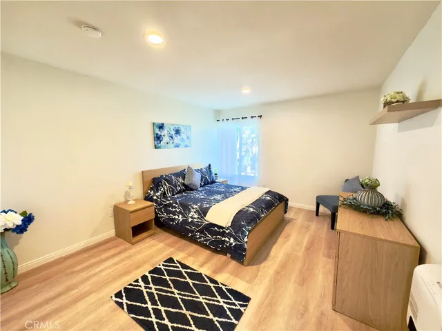 a bedroom with a bed and wooden floor