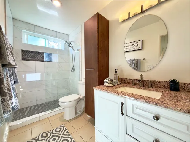 a bathroom with a granite countertop sink mirror and toilet