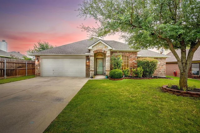 a front view of a house with a garden and trees