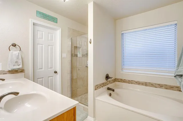 a bathroom with a tub sink and mirror