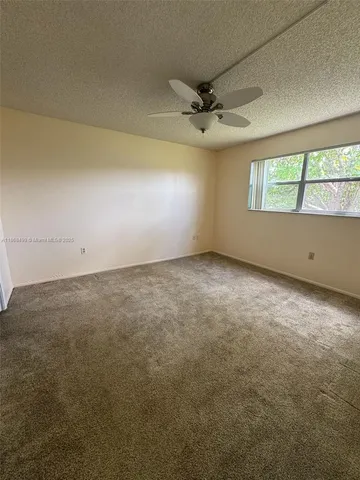 an empty room with a empty space and a ceiling fan