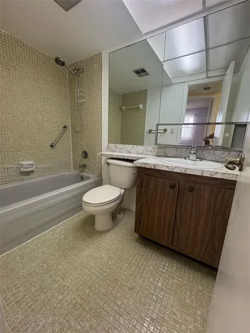 a bathroom with a granite countertop sink a toilet and shower