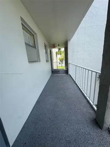 a view of a hallway to an empty room with stairs and stairs