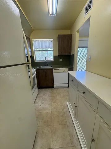a kitchen with a refrigerator and a sink