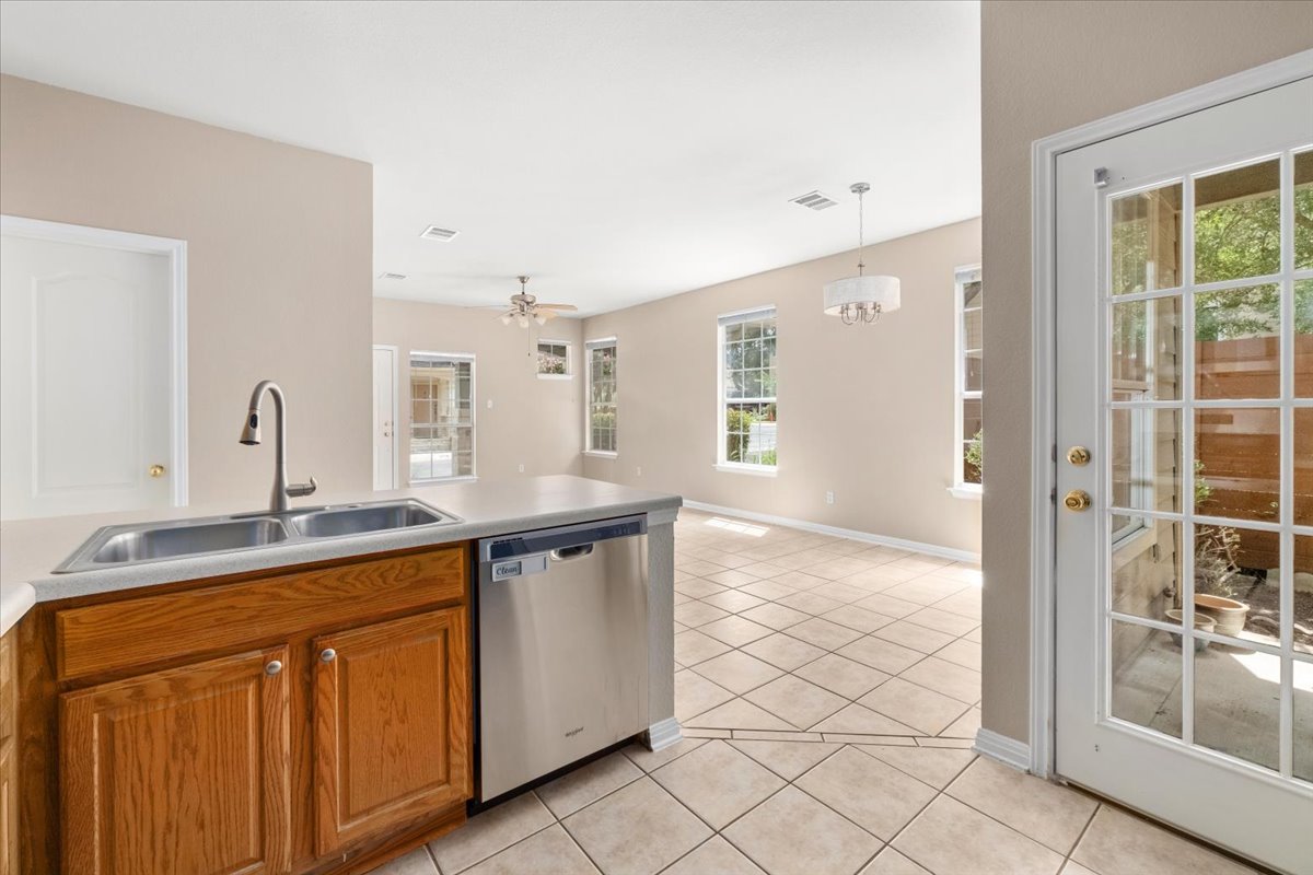 11000 Anderson Mill Road, Unit 11 Austin, TX 78750 - Photo 10 of 34 Functional kitchen island with stainless steel appliances seamlessly flows into a sunlit living space.