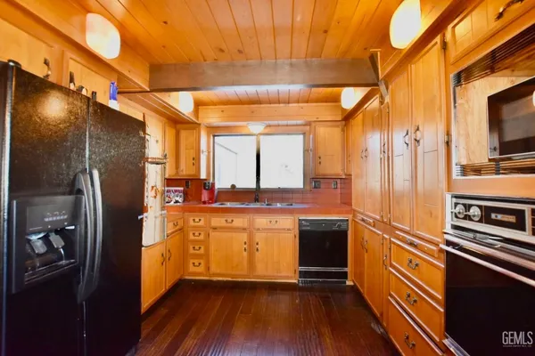 a kitchen with stainless steel appliances granite countertop a refrigerator a stove and a sink