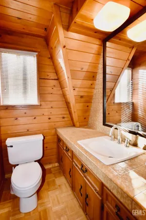 a bathroom with a granite countertop toilet sink and mirror