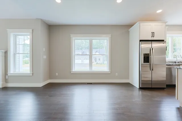 a view of a kitchen with wooden floor and a window