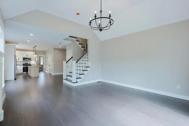 a view of an empty room with wooden floor and windows