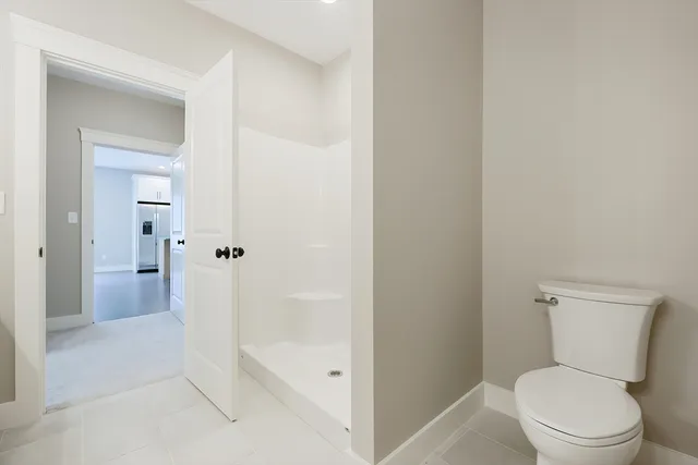 a bathroom with a toilet and a shower