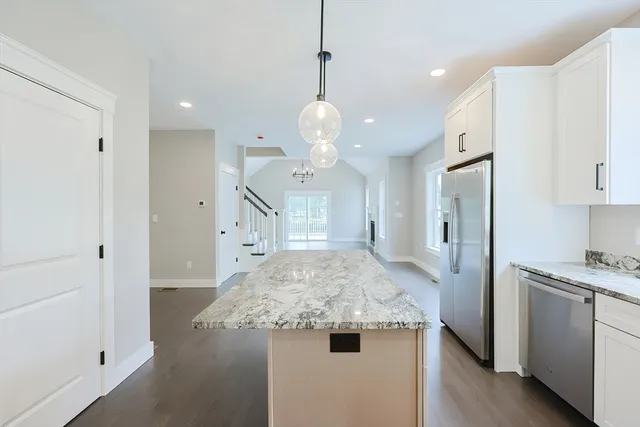 a kitchen with stainless steel appliances granite countertop a sink a refrigerator and a stove