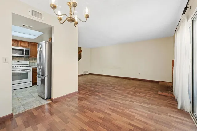 a view of a kitchen with wooden floor and a ceiling fan