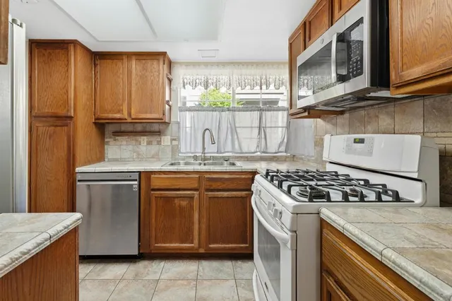 a kitchen with stainless steel appliances granite countertop a stove and a sink