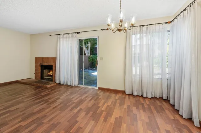 a view of a room with wooden floor stairs and a fireplace