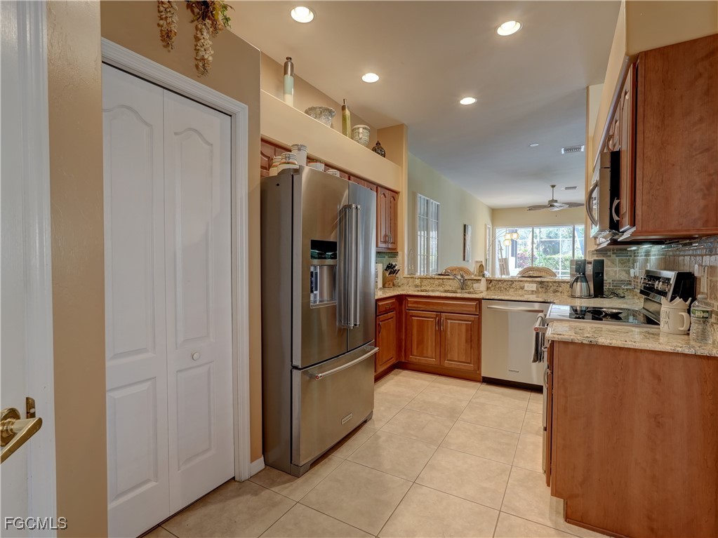11180 Wine Palm Road Fort Myers, FL 33966 - Photo 6 of 40 a kitchen with stainless steel appliances a refrigerator sink and cabinets