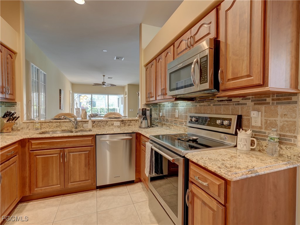 11180 Wine Palm Road Fort Myers, FL 33966 - Photo 7 of 40 a kitchen with stainless steel appliances granite countertop a stove sink and cabinets
