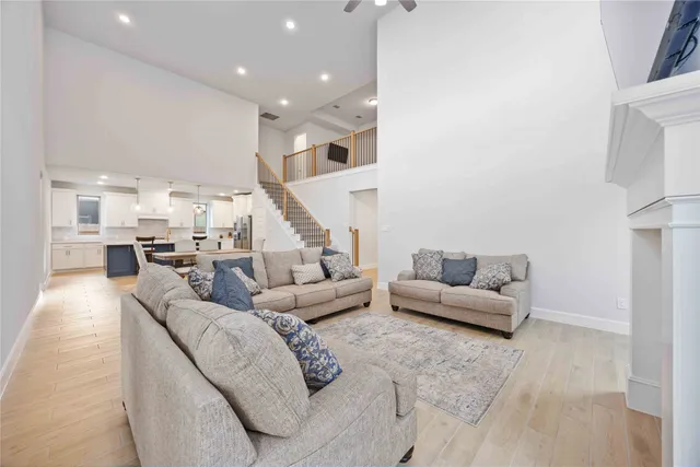a living room with couches and a view of kitchen