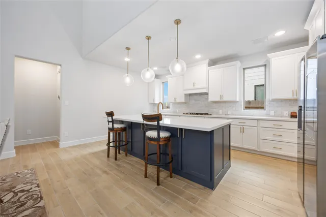 a kitchen with granite countertop a sink cabinets and wooden floor