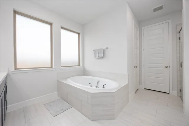 a white bath tub sitting in a bathroom next to a window