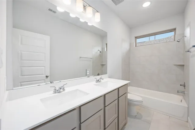 a bathroom with a sink double vanity granite tub and a mirror