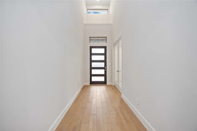 a view of a hallway with wooden floor and stairs