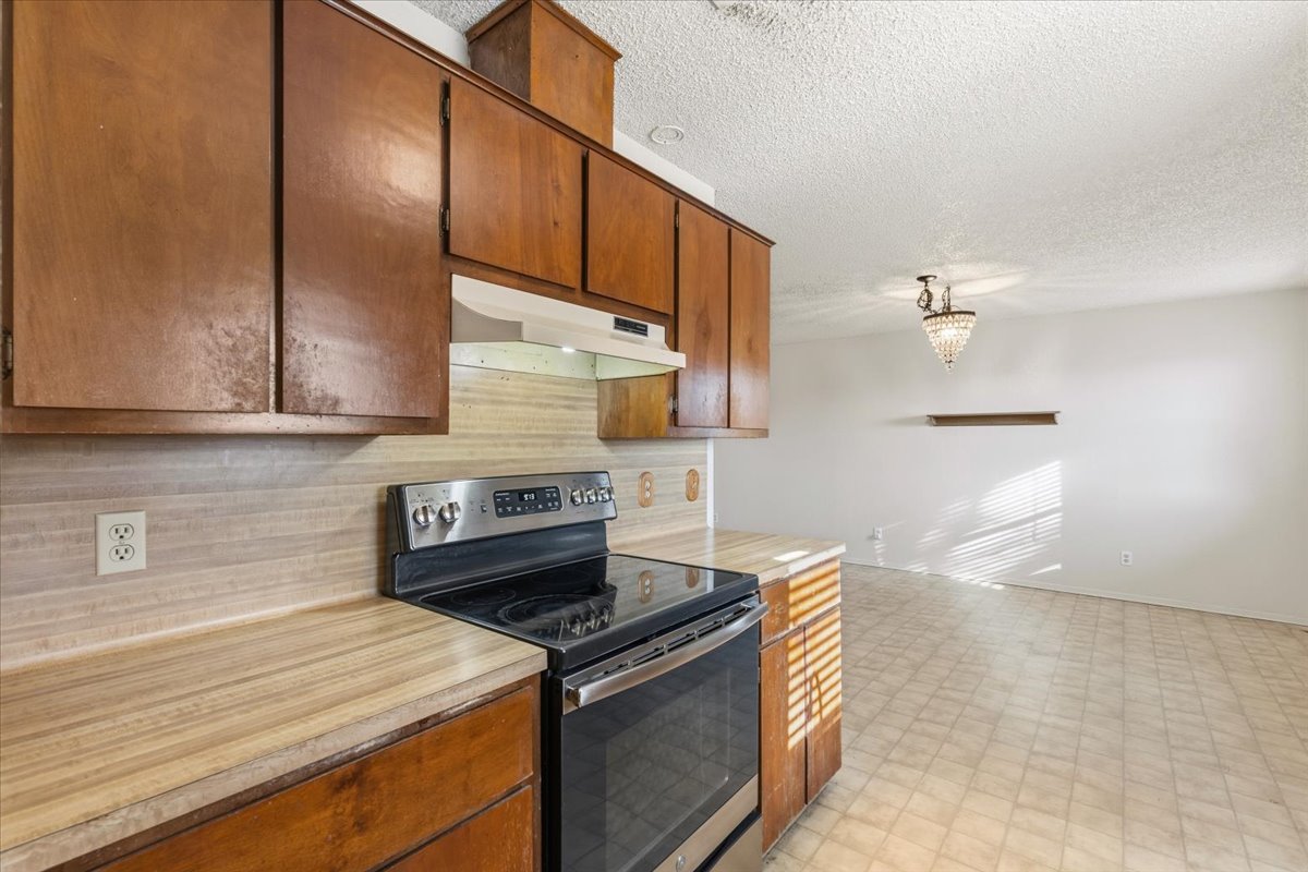 303 Ponderosa Road Bastrop, TX 78602 - Photo 11 of 34 a kitchen with stainless steel appliances granite countertop a stove a sink and a microwave