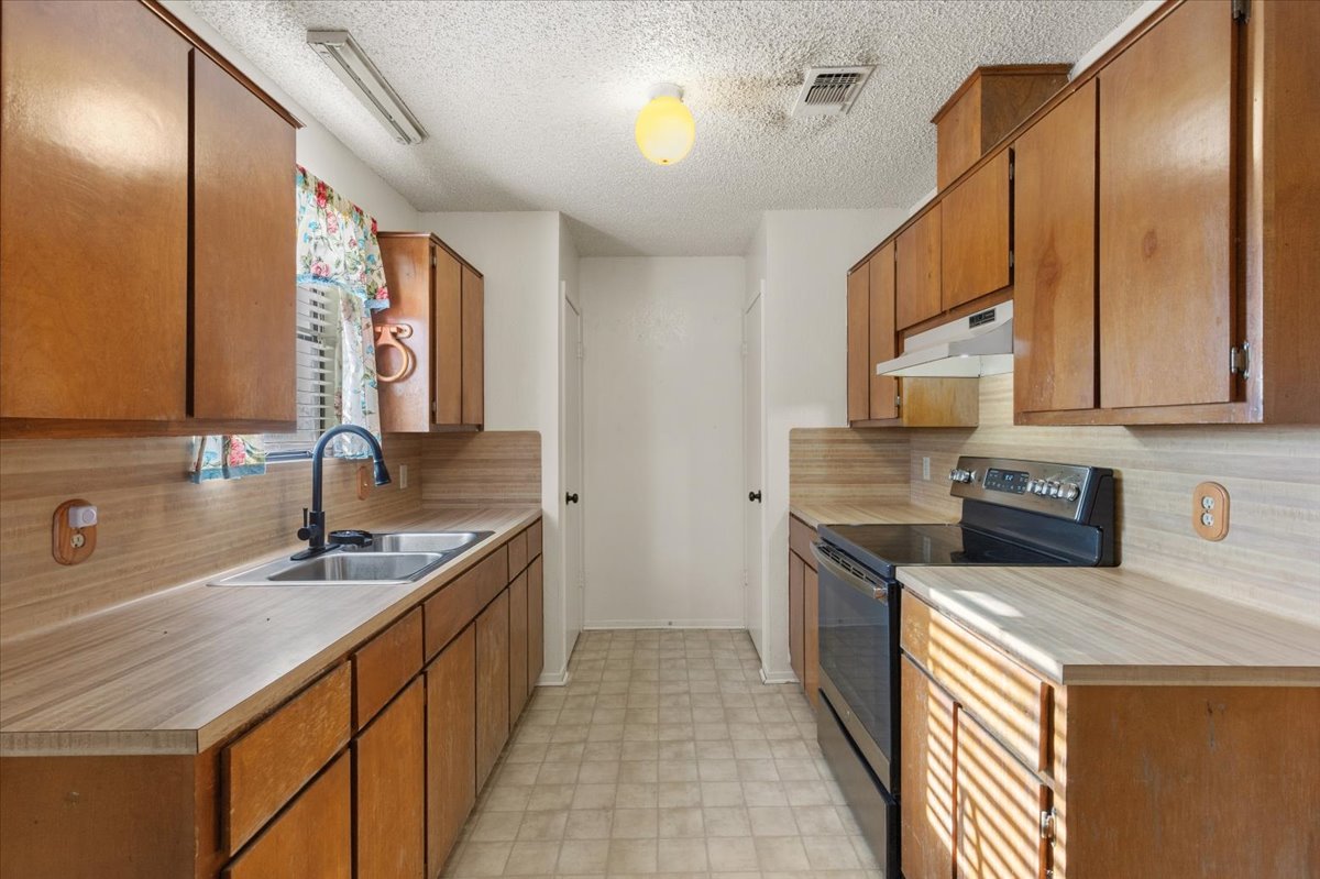 303 Ponderosa Road Bastrop, TX 78602 - Photo 13 of 34 a kitchen with a sink stove and cabinets