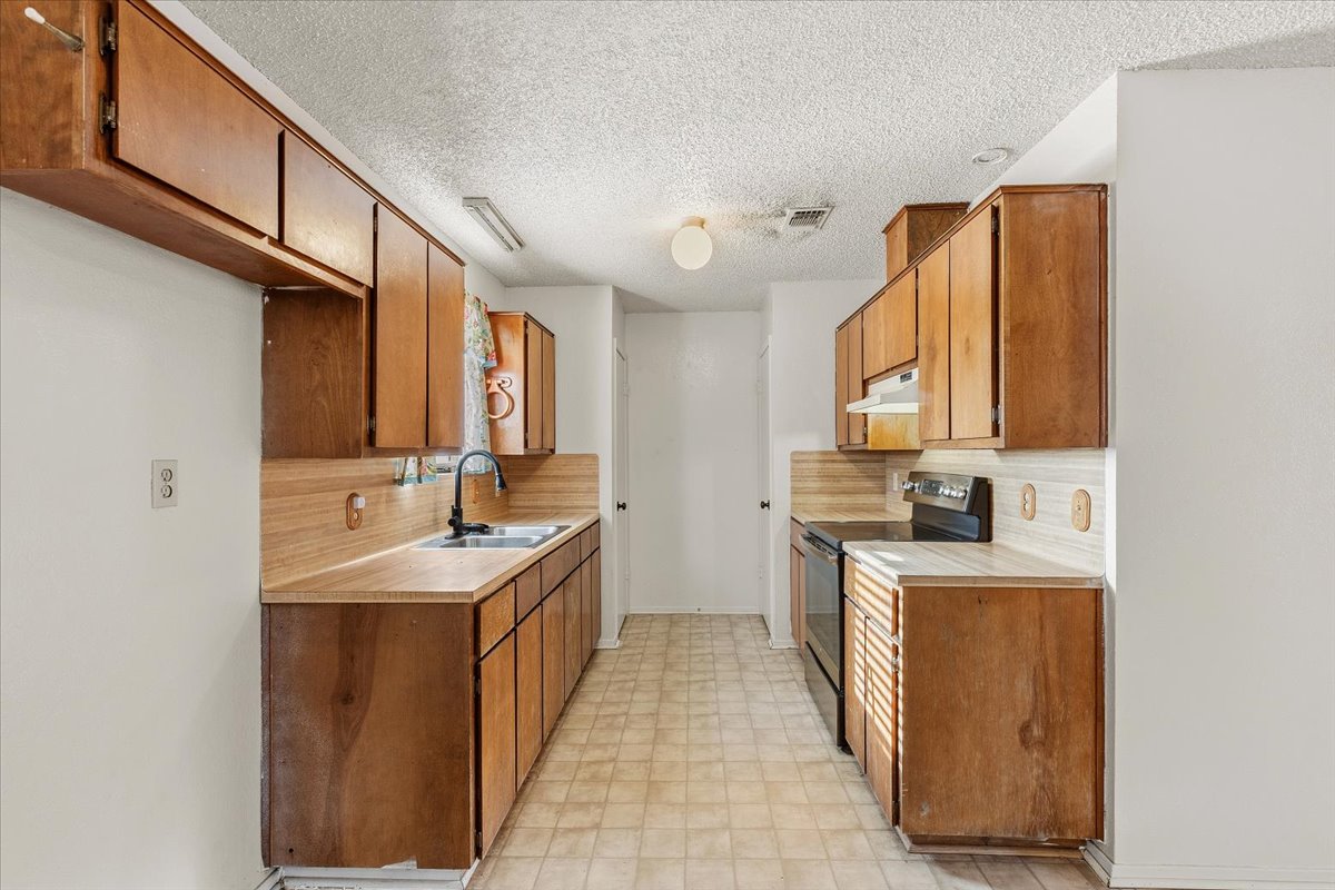 303 Ponderosa Road Bastrop, TX 78602 - Photo 14 of 34 a kitchen with a sink stove and cabinets