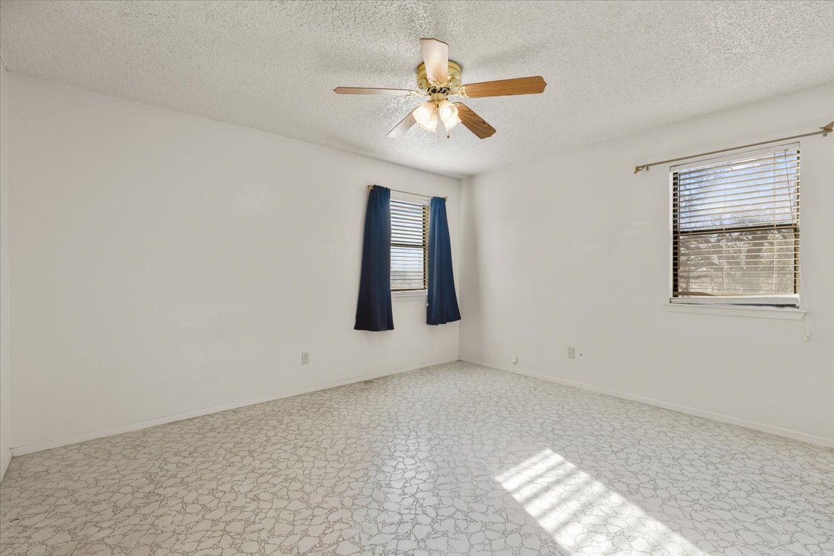 303 Ponderosa Road Bastrop, TX 78602 - Photo 15 of 34 an empty room with windows and fan
