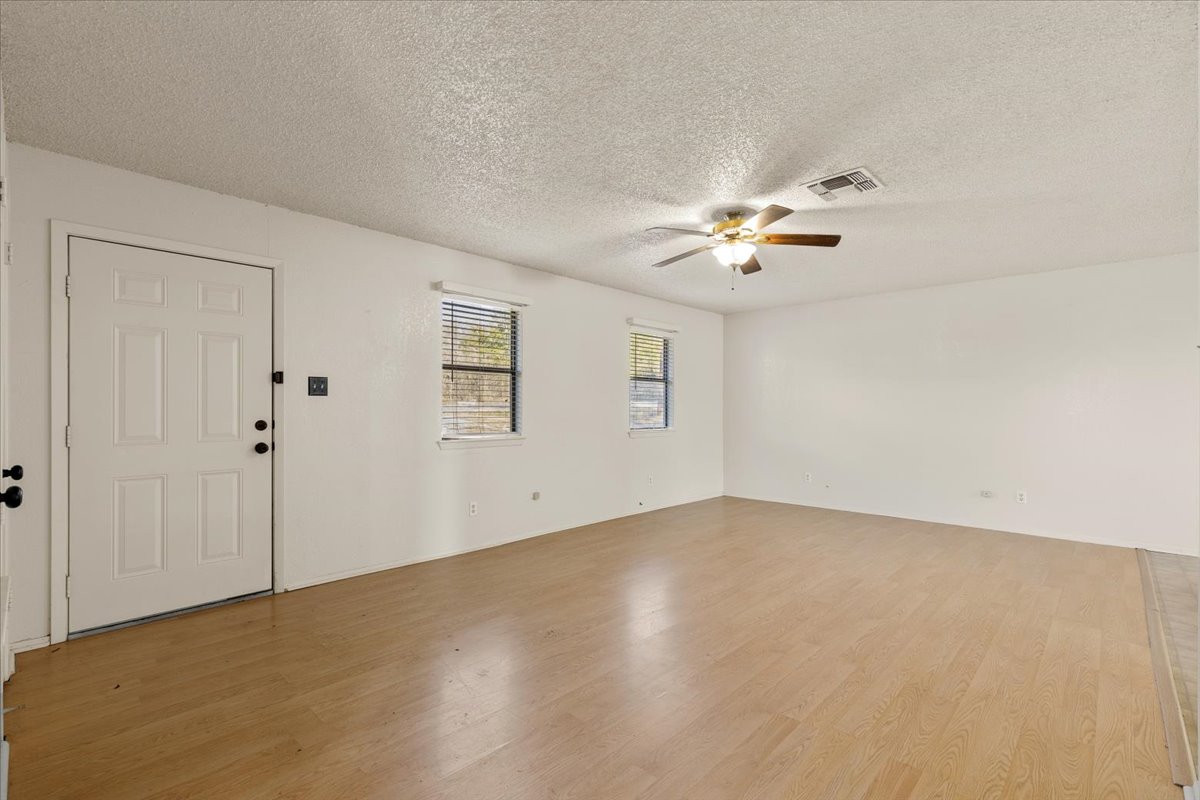 303 Ponderosa Road Bastrop, TX 78602 - Photo 5 of 34 a view of an empty room with a ceiling fan and window