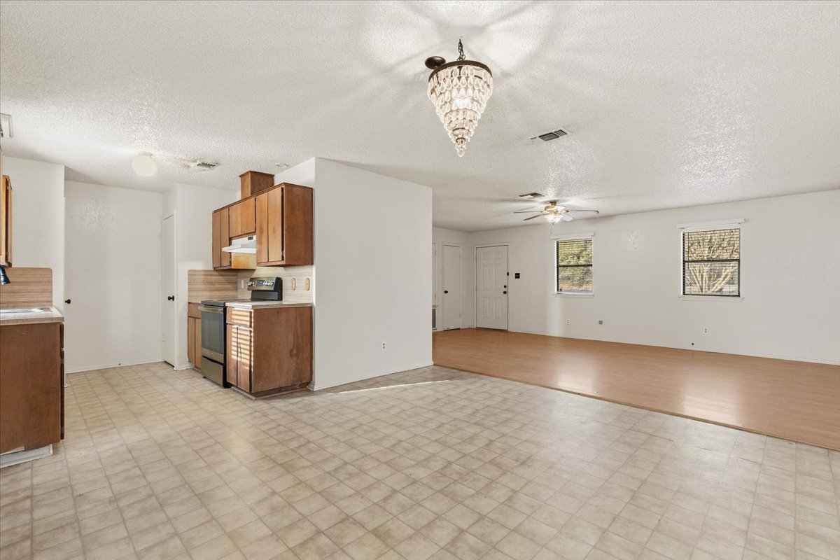 303 Ponderosa Road Bastrop, TX 78602 - Photo 10 of 34 a view of a kitchen with a stove cabinets and wooden floor
