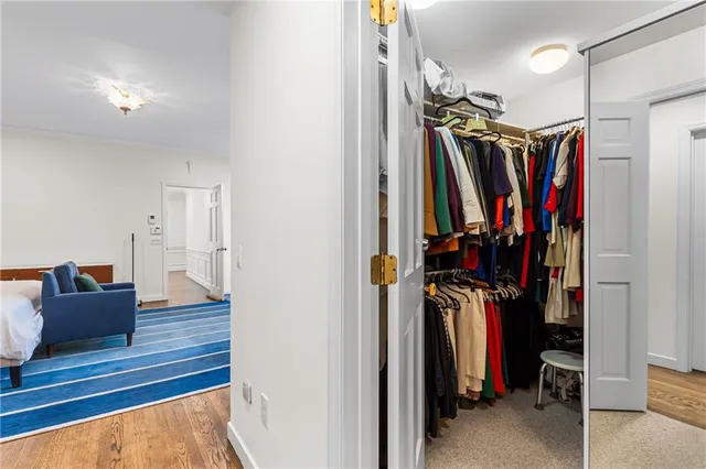 a view of walk in closet with clothes and shoes