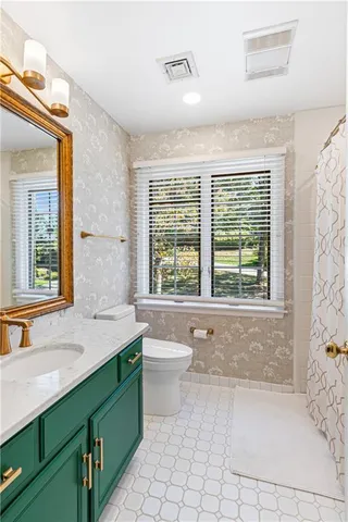 a bathroom with a granite countertop bathtub sink vanity mirror and next to a window